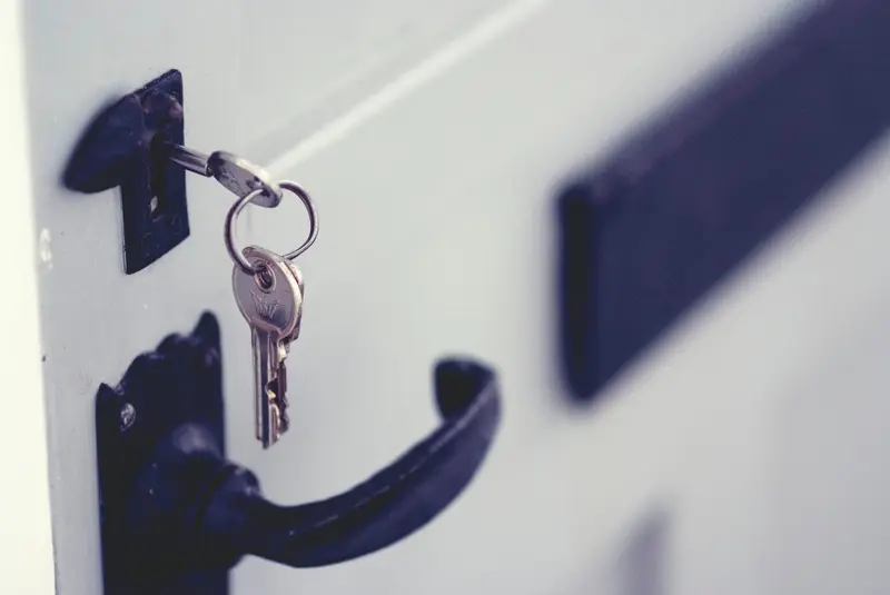 A set of keys hanging from a front door handle